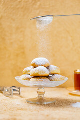 traditional Islamic Feast,Cookies for celebration of Eid El Fitr (Kahk) dusted with fine sugar with a cub of tea in the background 