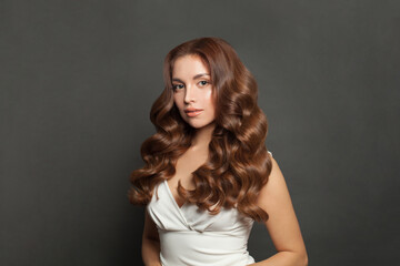 Curly Hair. Smiling Woman With Healthy Wavy Long Brown Hair. Portrait