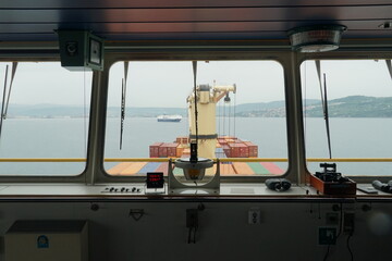 Koper, Slovenia - 05 06 2022: View through central window with gyro repeater of navigational bridge...