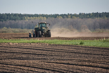 traktor pracuje na polu za nim wznoszący się kurz © Michal_Tu