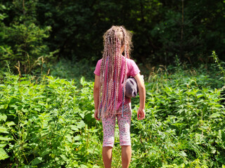 Hairstyle of little girl, kid with braided hair outdoor