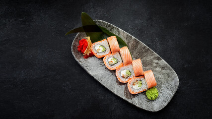 Roll Philadelphia with eel and salmon on a dark background