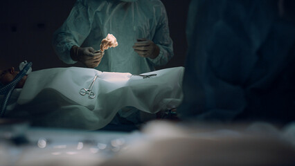 Professional surgeon begin surgical operation in dark hospital emergency room.