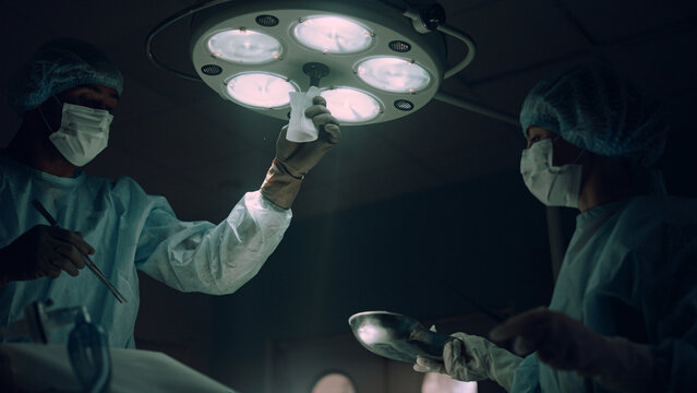 Doctor adjusting surgery lights in operating room. Hospital intensive care unit. - Powered by Adobe