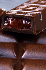 Broken Chocolate bar with fruit filling on a table. Dark chocolate macro view