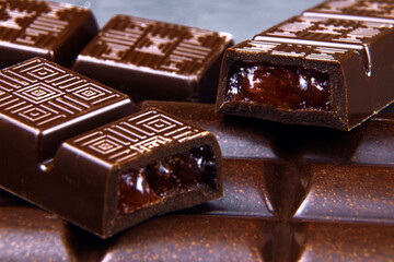 Broken Chocolate bar with fruit filling on a table. Dark chocolate macro view