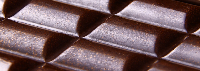 Porous dark Chocolate bar closeup banner. Porous chocolate macro view. Copy space. Vertical orientation