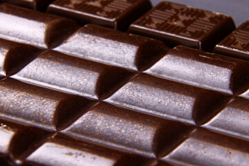 Porous dark Chocolate bar closeup. Porous chocolate macro view. Copy space. Vertical orientation