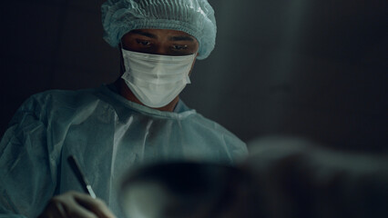 Portrait african american surgeon performing surgical operation in clinic room.