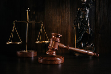 Law and justice concept. Mallet of the judge, scales and lady of justice on wooden background
