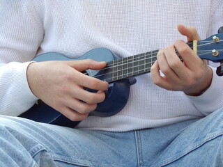 Young man playing an ukulele