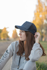 Red-haired woman in blue cap in park at sunset