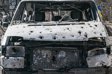 The minibus was shot to pieces. Blue and yellow flag looks out the side window (concept of Russian...