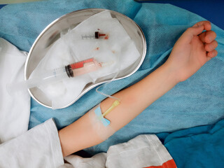 Taking blood from a vein in a child's arm. Taking a blood test.