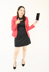 Naklejka premium Beautiful and successful asian businesswoman, in a black suit, pink jacket, satisfied managing her activities from her tablet, on a white backgroundd