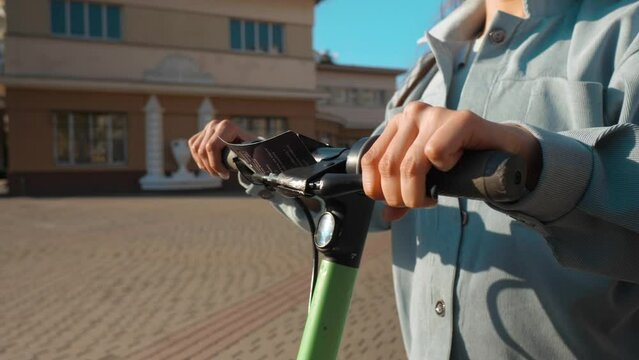 Closeup of female hands push a brakes on electric scooter