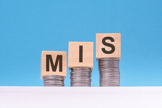 mis - text on wood cubes stack with coins