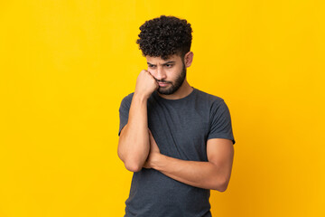 Young Moroccan man isolated on yellow background with tired and bored expression