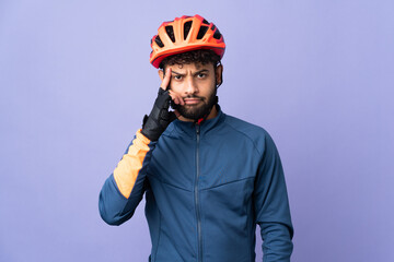 Young Moroccan cyclist man isolated on purple background thinking an idea - obrazy, fototapety, plakaty