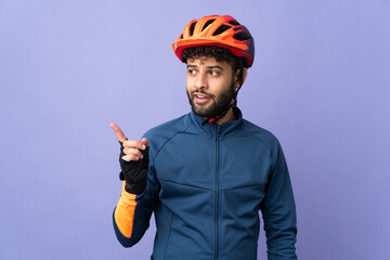 Young Moroccan cyclist man isolated on purple background intending to realizes the solution while lifting a finger up