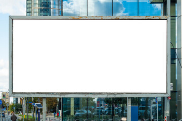 Blank white advertising billboard in front of modern office building with glass facade