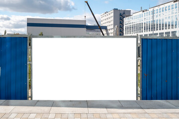 Blank white advertising billboard on the fence of construction site