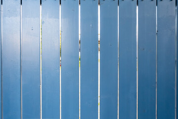 Blue fence made of wood. Sunny summer day in the city