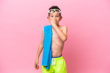 Little caucasian boy wearing a diving goggles isolated on pink background © luismolinero