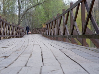 MOSCOW, RUSSIA - May 3, 2022. Wooden platform by the pond in the park