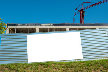 Blank white banner for advertisement on the fence of construction site © diesirae