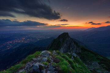 Cloudy scene on the top of the Giewont mountain just before the sunrise. Below the mountains Zakopane city is awakening.