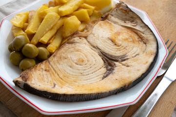 Seafood dish, grilled steak from swordfish or spada served with french fried potatoes and green olives