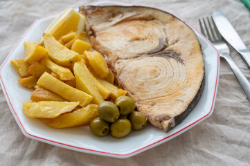 Seafood dish, grilled steak from swordfish or spada served with french fried potatoes and green olives