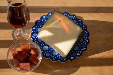 Spanish hard manchego, cow, sheep and goat cheeses served outdoor with membrillo jam and glass of sherry wine in sunlights