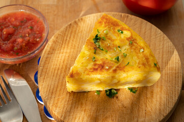 Spanish vegetarian food, portion of homemade potato omelette tortilla de patatas with onion served outdoor in morning sunlights