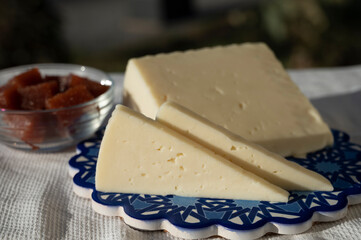 Spanish hard goat cheese served outdoor with membrillo jam with blue sea on background