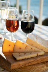 Spanish hard Andalusian cheese filled with Pedro Ximenez sweet sherry served outdoor with two glasses of sherry wine with blue sea on background
