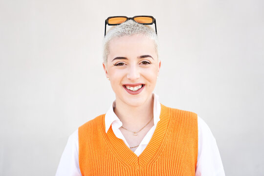Portrait of young woman looking at camera. Close up face of cheerful girl smiling outdoor. Confident beautiful happy empowered entrepreneur shaved hair lady