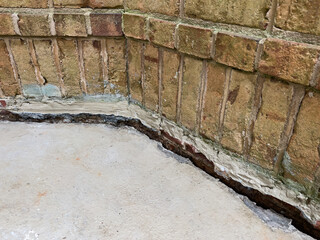 Sinking concrete foundation in need of mudjacking leveling repair. Sunken cement slab porch.
