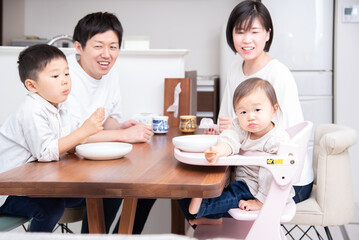 Obraz na płótnie Canvas ダイニングテーブルでおやつを食べている家族
