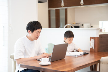 Obraz premium 家で仕事をしている男性と5歳の男の子