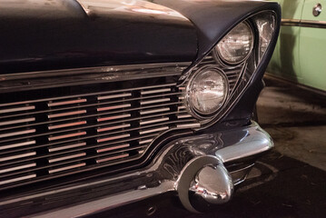 A headlight and a shiny car bumper