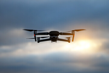 Foldable drone copter flying with a digital camera in mountains.