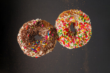 Two donuts in a frozen flight on a gray background. Sweet food, happy hormone, american breakfast, fast food. Advertising, banner, birthday invitation, date.