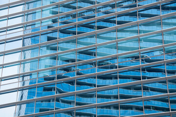 Blue sky reflection in glass facade of building