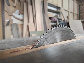Closeup of a wood cutting table with electric circular saw at woodworking workshop 