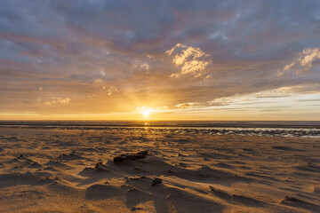 Beautiful sunset with dramatic moody cloudy sky above the ocean of North Sea, De Haan, Belgium.