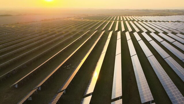 Aerial view of large sustainable electrical power plant with rows of solar photovoltaic panels for producing clean electric energy in evening. Concept of renewable electricity with zero emission