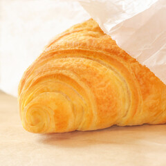 Part of a croissant on a blurred background in a square