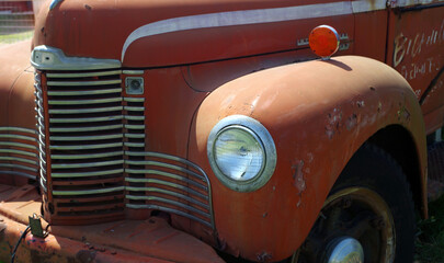 Old rusty truck - partial closeup of grille and headlight